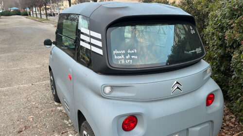 Una Citroën Ami in un parcheggio di Aosta, con la scritta, originale, 'please don't honk at me, I'll cry'