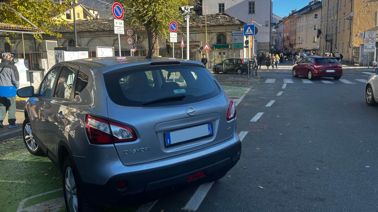Un'auto termica posteggiata abusivamente nello stallo per la ricarica di auto elettriche, davanti una colonnina HPC